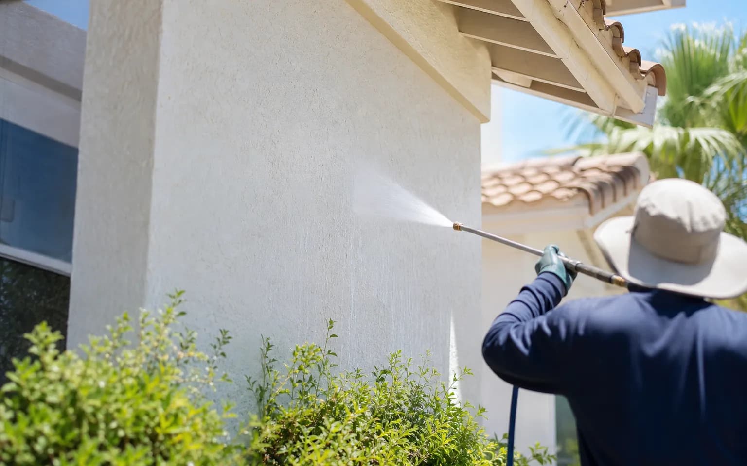 Freshly cleaned two-story stucco home with a tile roof, bright walls, a spotless concrete driveway and clear windows on a sunny day